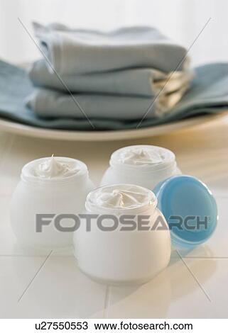 Jars of moisturizing creams and stack of towels View Large Photo Image Stock Image - Jars of moisturizing creams and stack of towels. Fotosearch