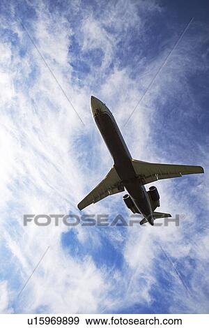 Stock Photo - Low angle view of airplane in sky. Fotosearch