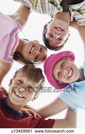 Low angle view of children in a huddle View Large Photo Image Stock Image - Low angle view of children in a huddle. Fotosearch
