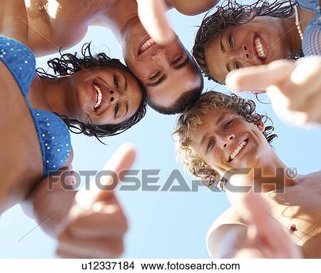 Picture - Low angle view of young friends in huddle. Fotosearch