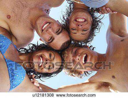 Low angle view of young friends in huddle View Large Photo Image Stock Photo - Low angle view of young friends in huddle. Fotosearch