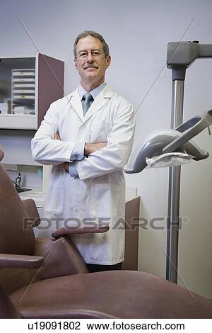 Stock Image - Male dentist with arms crossed. Fotosearch
