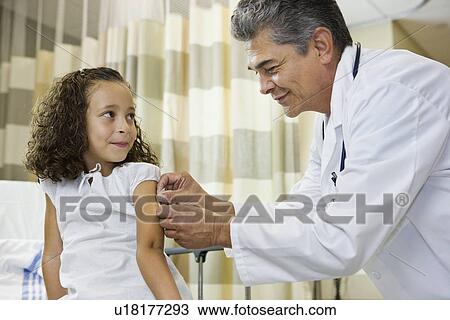 Male doctor bandaging girl’s arm View Large Photo Image Stock Image - Male doctor bandaging girl’s arm. Fotosearch