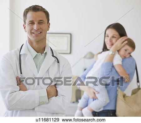 Stock Photo - Male doctor in front of mother and son. Fotosearch