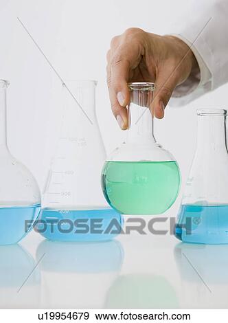 Male scientist holding beaker of liquid View Large Photo Image Stock Photo - Male scientist holding beaker of liquid. Fotosearch