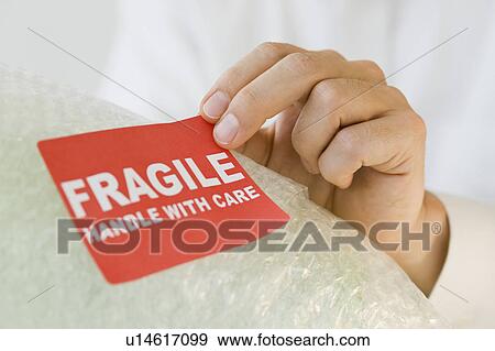 Man affixing fragile sticker View Large Photo Image Stock Photo - Man affixing fragile sticker. Fotosearch