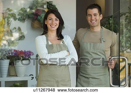 Stock Photo - Man and woman standing in doorway of flower shop. Fotosearch