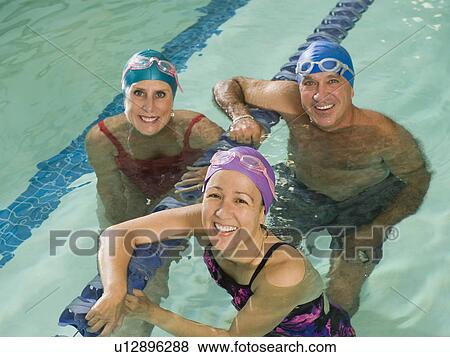 Stock Photo - Man and women posing in swimming pool. Fotosearch