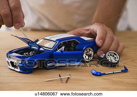 Stock Photo - Man assembling model car. Fotosearch