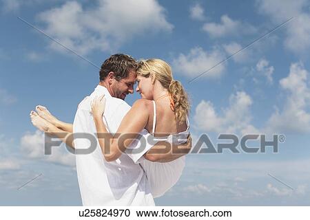 Man carrying girlfriend on beach View Large Photo Image Stock Image - Man carrying girlfriend on beach. Fotosearch