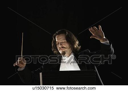 Stock Photography - Man conducting behind music stand. Fotosearch