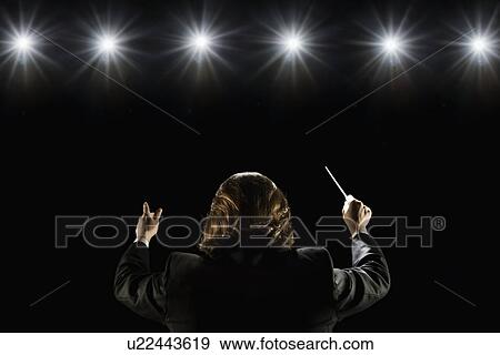 Man conducting under lights View Large Photo Image Stock Photo - Man conducting under lights. Fotosearch