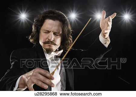 Man conducting under lights View Large Photo Image Stock Photo - Man conducting under lights. Fotosearch