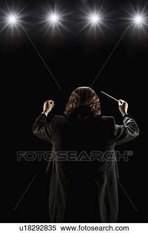 Stock Photography - Man conducting under lights. Fotosearch