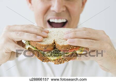 Stock Photo - Man eating sandwich. Fotosearch
