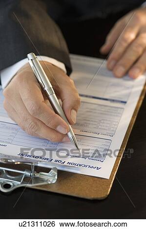 Stock Photograph - Man filling out employment application. Fotosearch