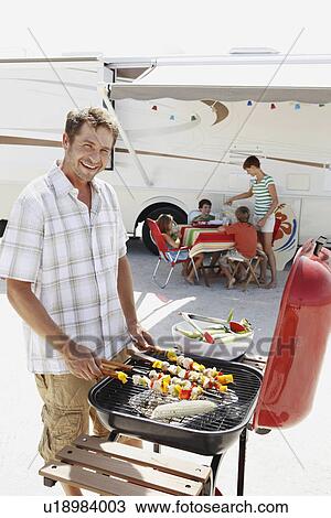 Man grilling dinner for family on beach View Large Photo Image Stock Image - Man grilling dinner for family on beach. Fotosearch
