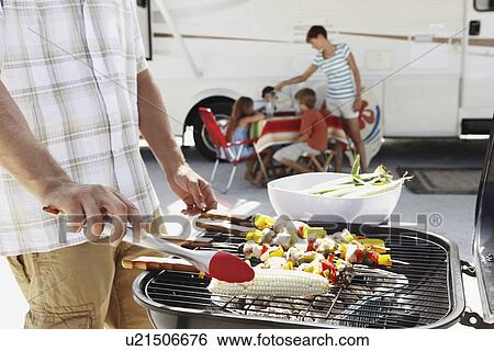 Man grilling dinner for family on beach View Large Photo Image Stock Photograph - Man grilling dinner for family on beach. Fotosearch