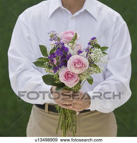 Stock Photo - Man holding bouquet of flowers. Fotosearch