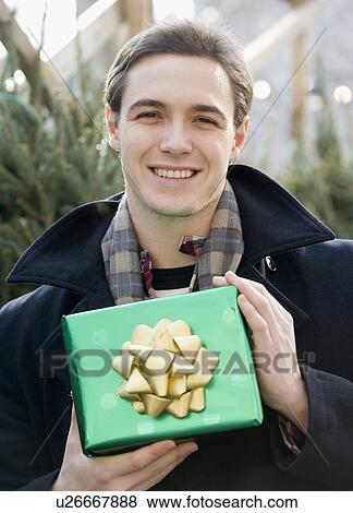 Man holding gift View Large Photo Image Stock Photo - Man holding gift. Fotosearch