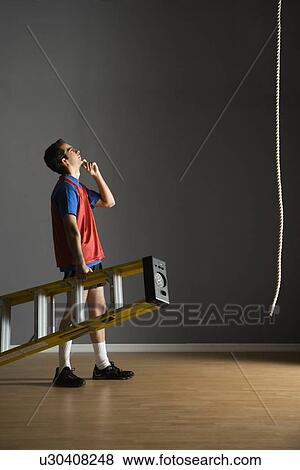 Man holding ladder and looking at rope View Large Photo Image Stock Photo - Man holding ladder and looking at rope. Fotosearch
