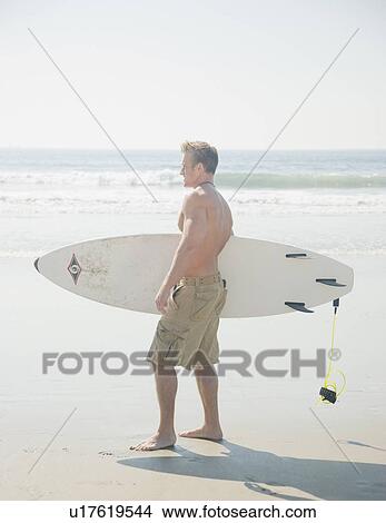 Man holding surfboard View Large Photo Image Picture - Man holding surfboard. Fotosearch