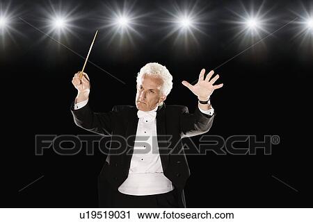 Man in tuxedo conducting under lights View Large Photo Image Stock Image - Man in tuxedo conducting under lights. Fotosearch