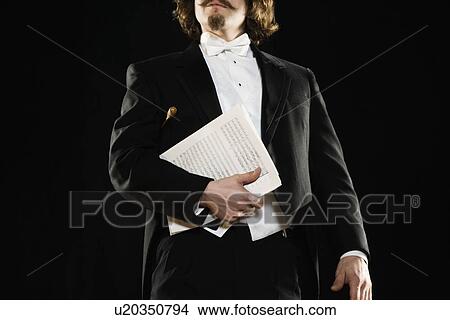 Picture - Man in tuxedo holding sheet music. Fotosearch