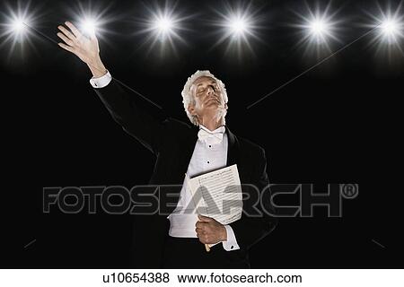 Stock Photo - Man in tuxedo holding sheet music. Fotosearch