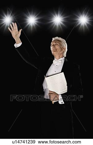 Stock Photo - Man in tuxedo holding sheet music. Fotosearch