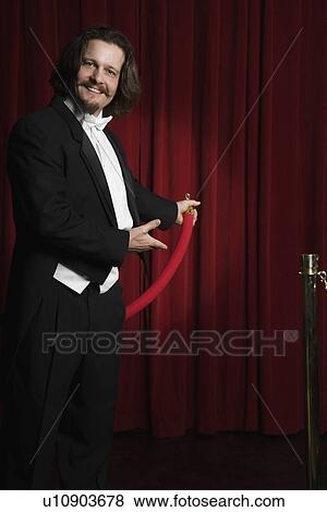 Man in tuxedo holding velvet rope View Large Photo Image Stock Photo - Man in tuxedo holding velvet rope. Fotosearch