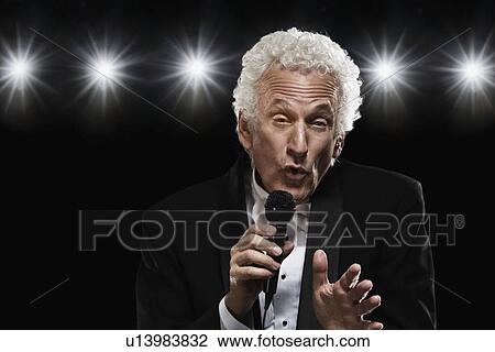 Man in tuxedo singing into microphone View Large Photo Image Stock Image - Man in tuxedo singing into microphone. Fotosearch