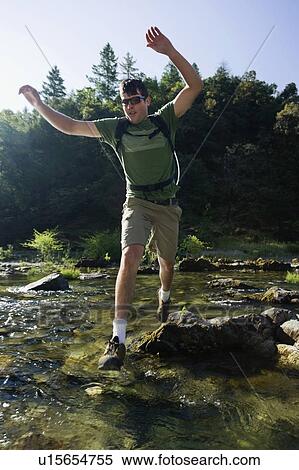 Man jumping across river on rocks View Large Photo Image Stock Photography - Man jumping across river on rocks. Fotosearch