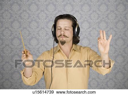 Man listening to headphones and conducting View Large Photo Image Stock Photo - Man listening to headphones and conducting. Fotosearch