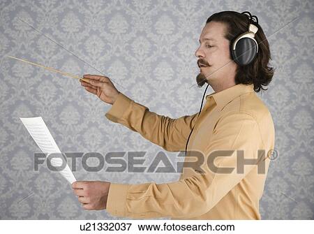 Man listening to headphones and conducting View Large Photo Image Stock Photo - Man listening to headphones and conducting. Fotosearch