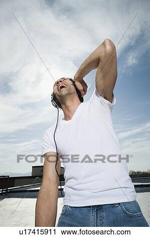 Stock Image - Man listening to headphones. Fotosearch