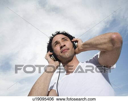 Man listening to headphones View Large Photo Image Stock Photograph - Man listening to headphones. Fotosearch