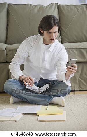 Stock Image - Man looking at electronic organizer. Fotosearch