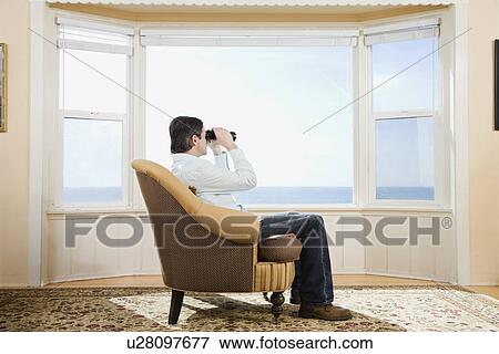 Man looking through binoculars View Large Photo Image Stock Photo - Man looking through binoculars. Fotosearch
