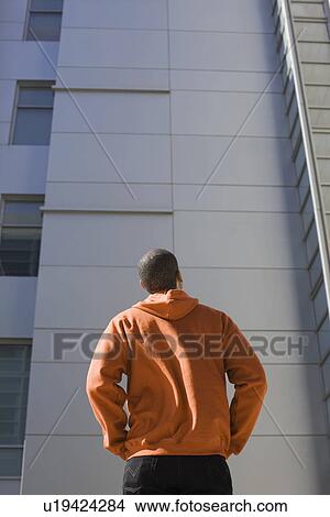 Picture - Man looking up at highrise. Fotosearch