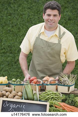Man next to baskets of vegetables View Large Photo Image Stock Photograph - Man next to baskets of vegetables. Fotosearch