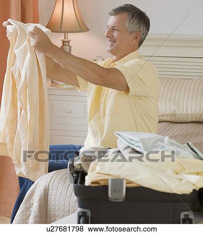 Stock Photo - Man packing suitcase. Fotosearch