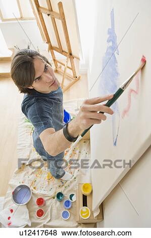 Stock Photo - Man painting on easel. Fotosearch