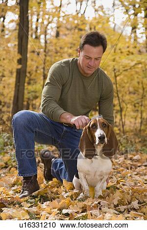 Stock Image - Man petting dog outdoors. Fotosearch