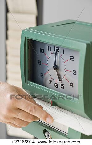 Picture - Man punching card in time clock. Fotosearch