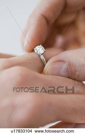 Man putting engagement ring on woman’s finger View Large Photo Image Picture - Man putting engagement ring on woman’s finger. Fotosearch