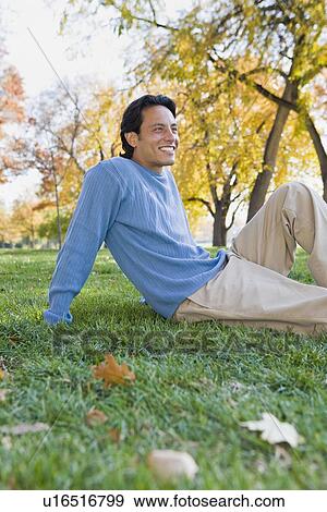 Stock Photo - Man sitting in grass. Fotosearch