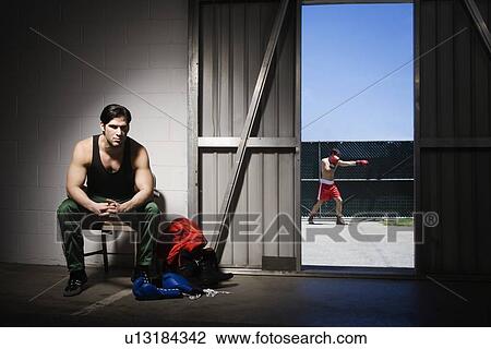 Man sitting on stool by doorway with boxer in background View Large Photo Image Stock Image - Man sitting on stool by doorway with boxer in background. Fotosearch