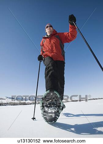 Stock Image - Man snow shoeing. Fotosearch