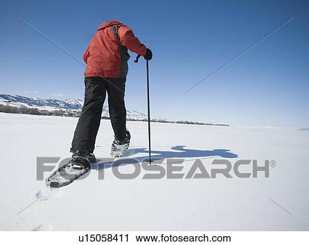 Stock Image - Man snow shoeing. Fotosearch